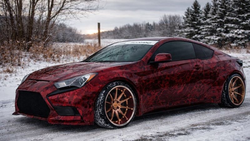 A car wrapped in red marble wrap to improve its aesthetics