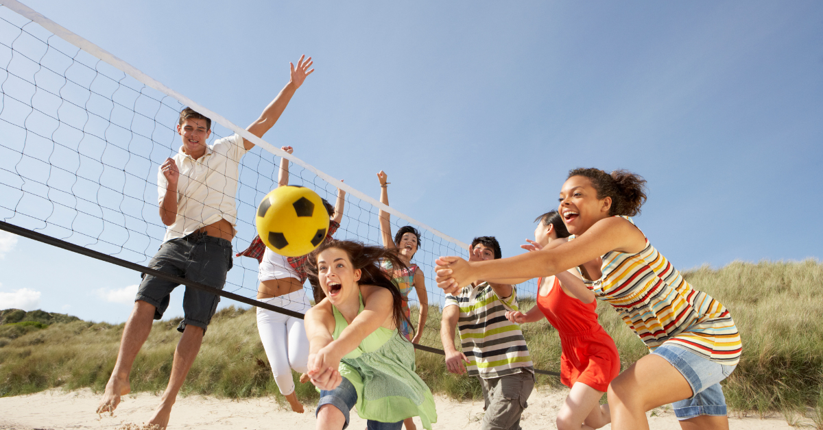 Group of friends playing beach volleyball on the sandy shores of Sea Isle City, NJ during summer vacation.