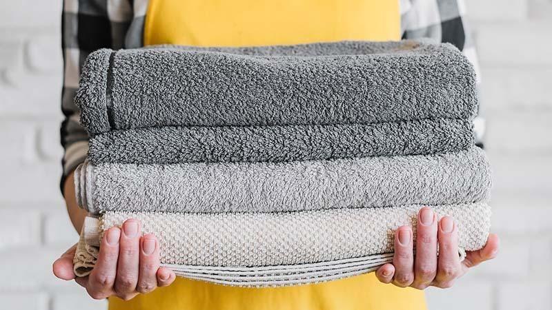 Cleaning Staff holding a stack of fluffy loop towels