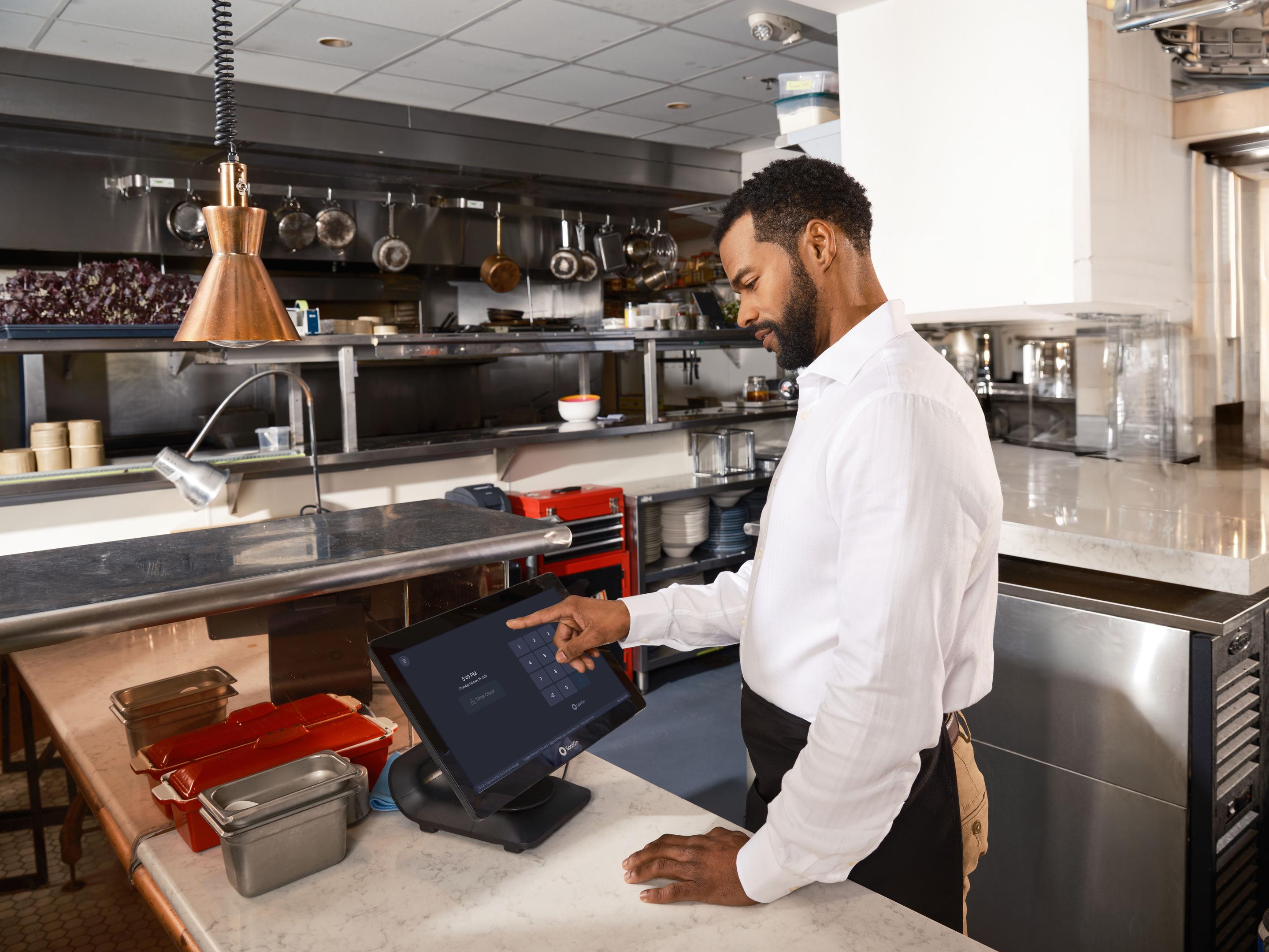 Busy restaurant host stand with a ringing phone while staff serve tables in the background