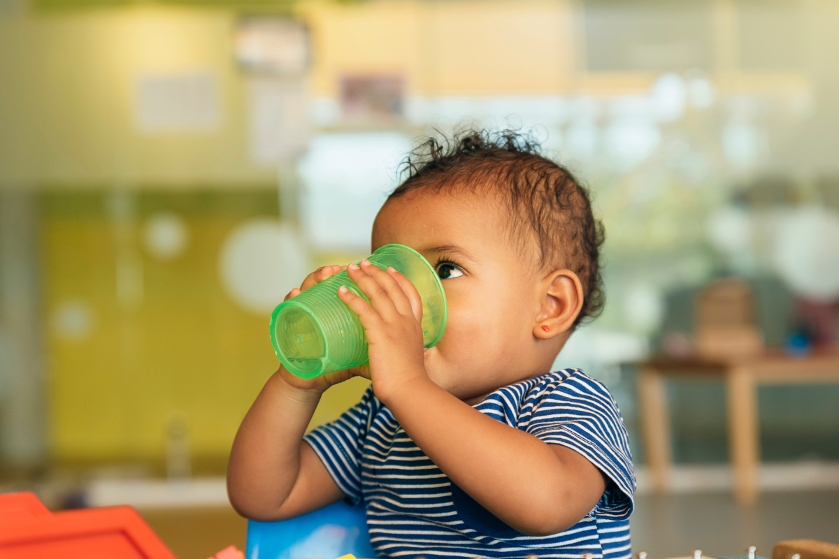 A little boy drinking a cup of water