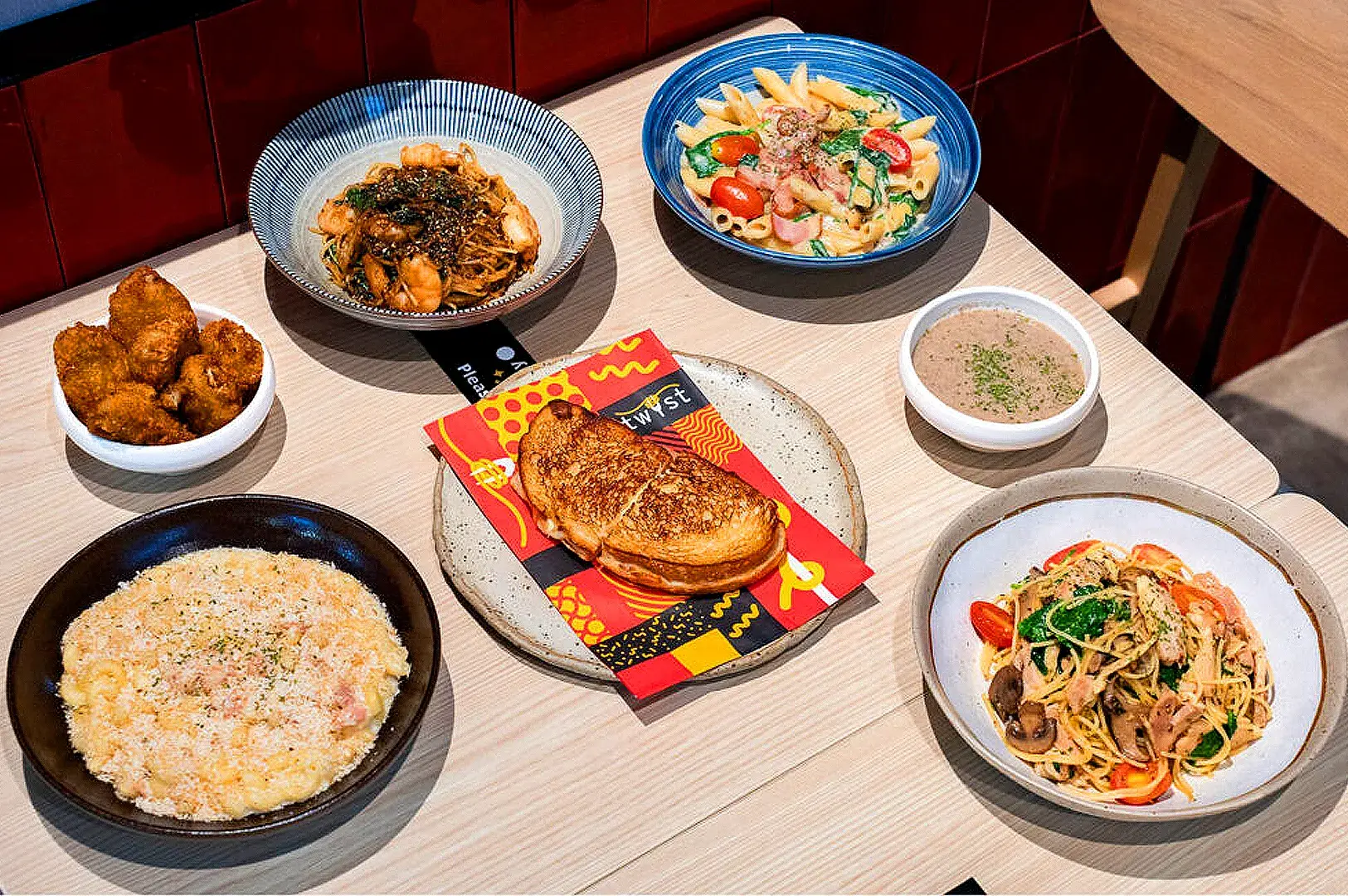Signature pasta, grilled sandwich, soup, and side dishes at Twyst Singapore restaurant in Raffles City.