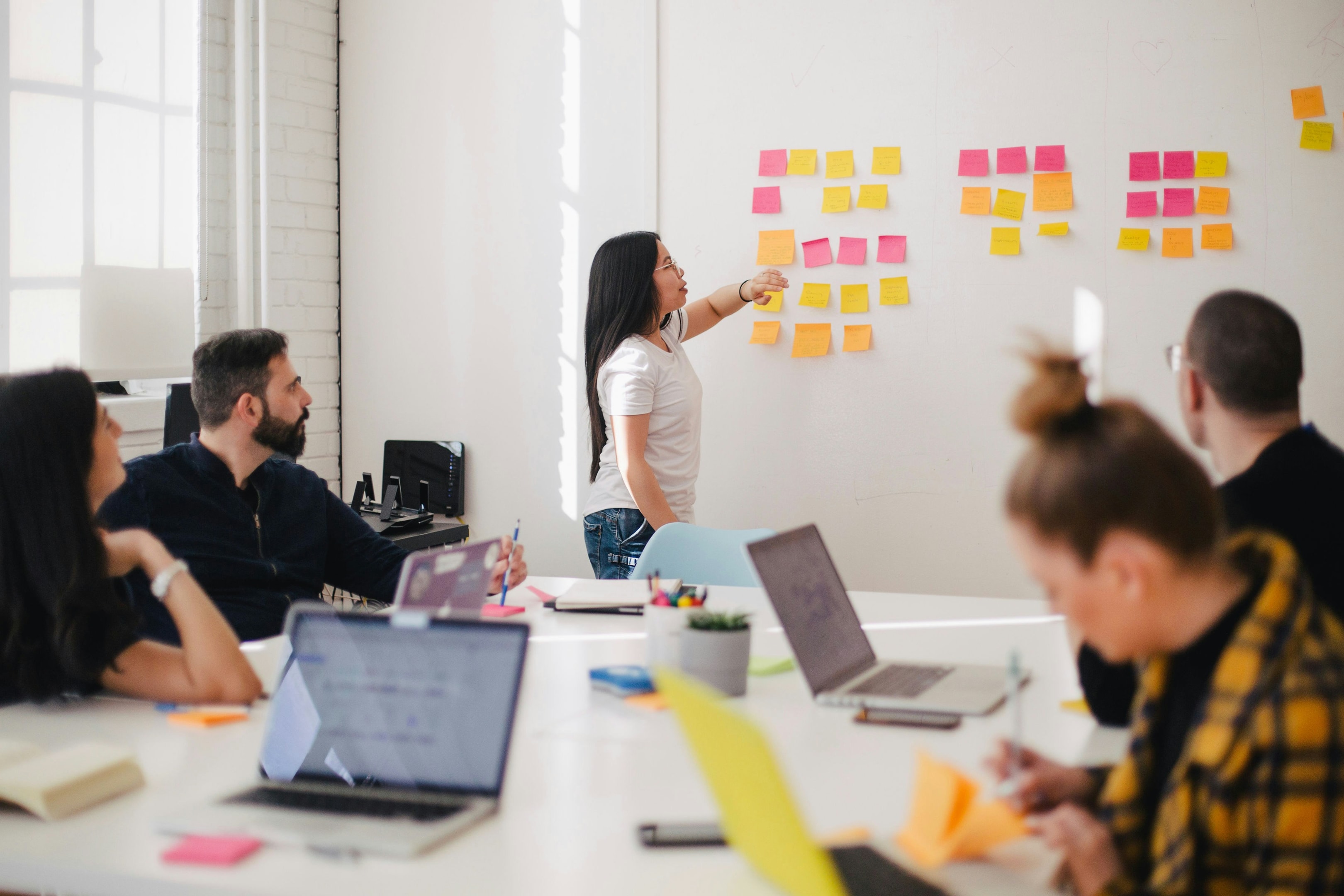 Woman placing post-it notes on a whiteboard