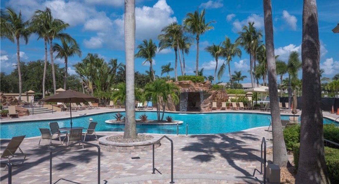The image depicts a scenic entrance to a gated community featuring security gates, beautifully landscaped greenery, and welcoming signage that highlights the Legends Golf and Country Club. This inviting setting sets the tone for a legendary experience, showcasing the community's picturesque surroundings and access to top-tier golf courses and amenities.