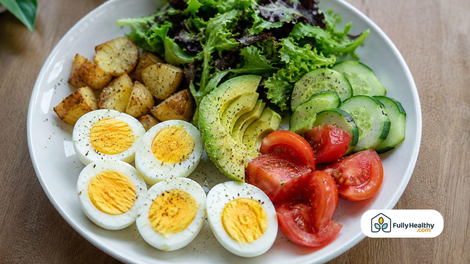 Hard-boiled eggs served with avocado, potatoes, tomatoes, and fresh greens.