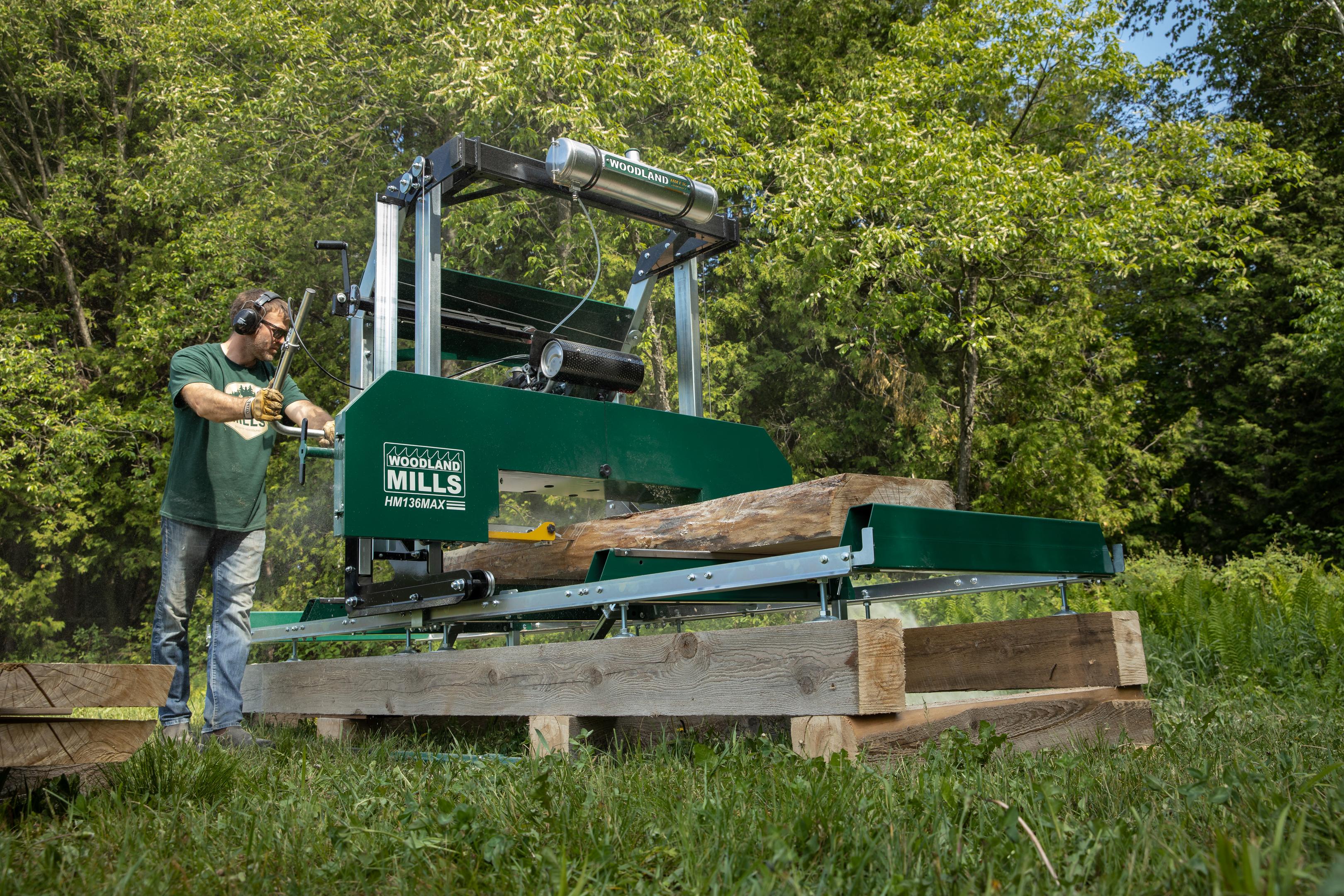 A man using his HM136MAX band saw mill to mill into a log for making a live-edge slab table. 