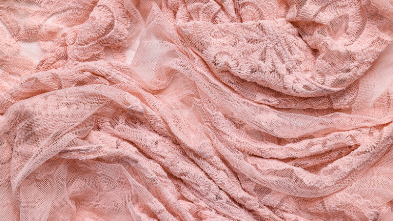 A close up view of a pink lace fabric