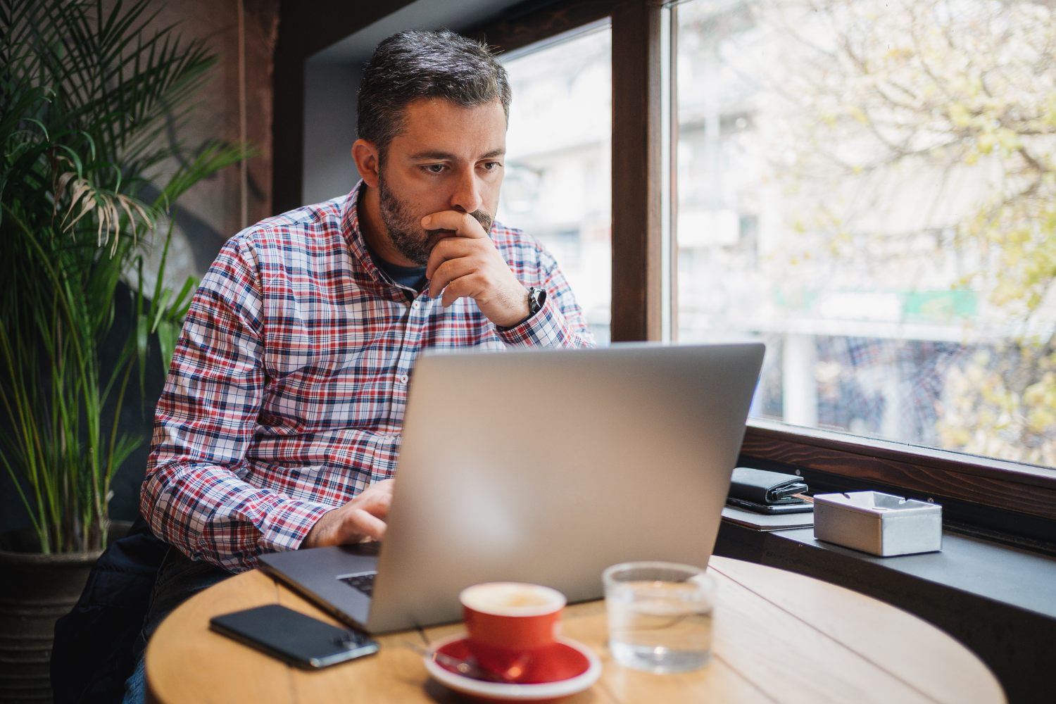 A business owner reading email responses on his laptop.