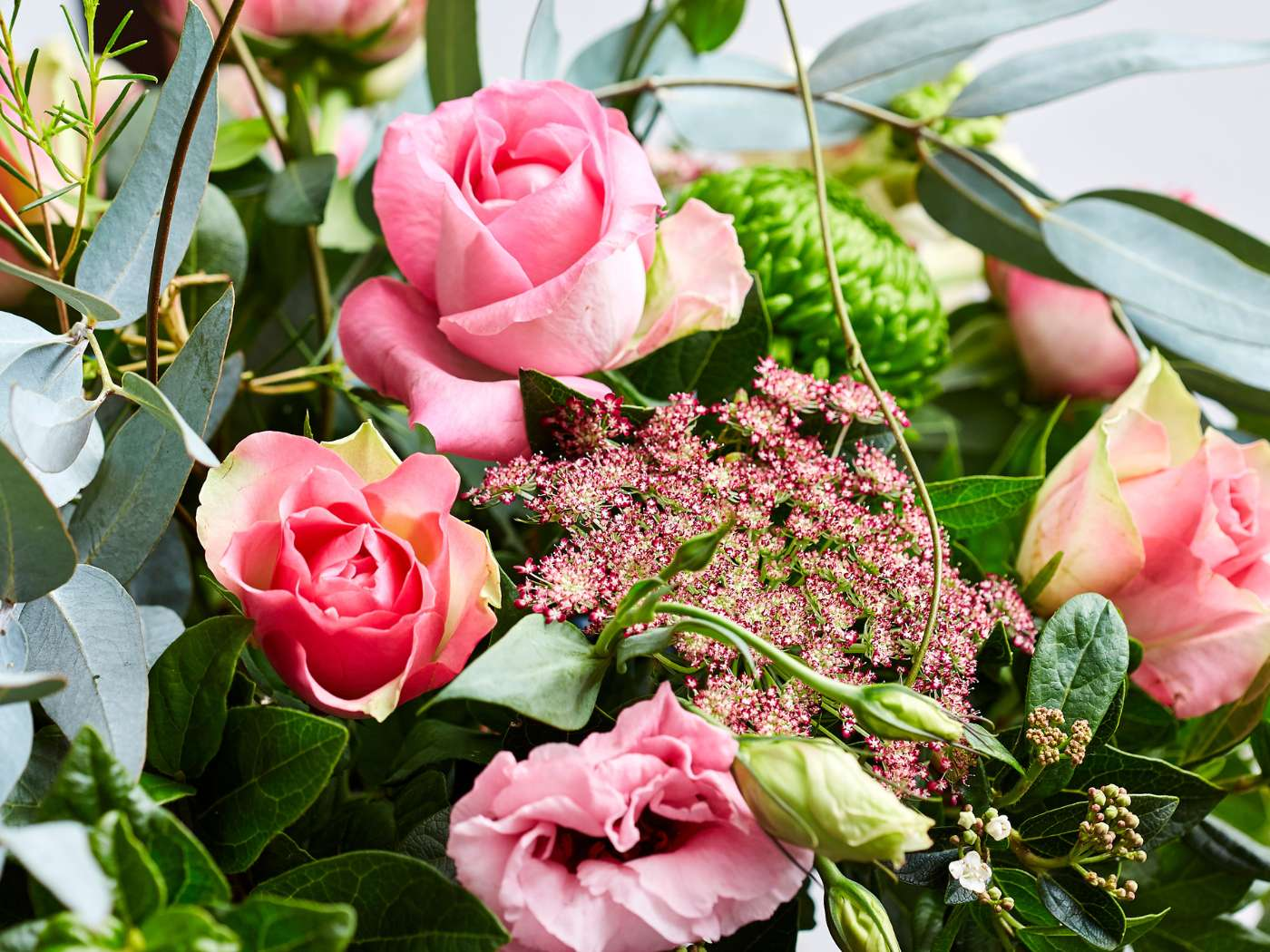 Close-up of a vibrant flower arrangement with pink roses, green foliage, and delicate pink blossoms, part of the Fabulous Flowers and Gifts company collection.