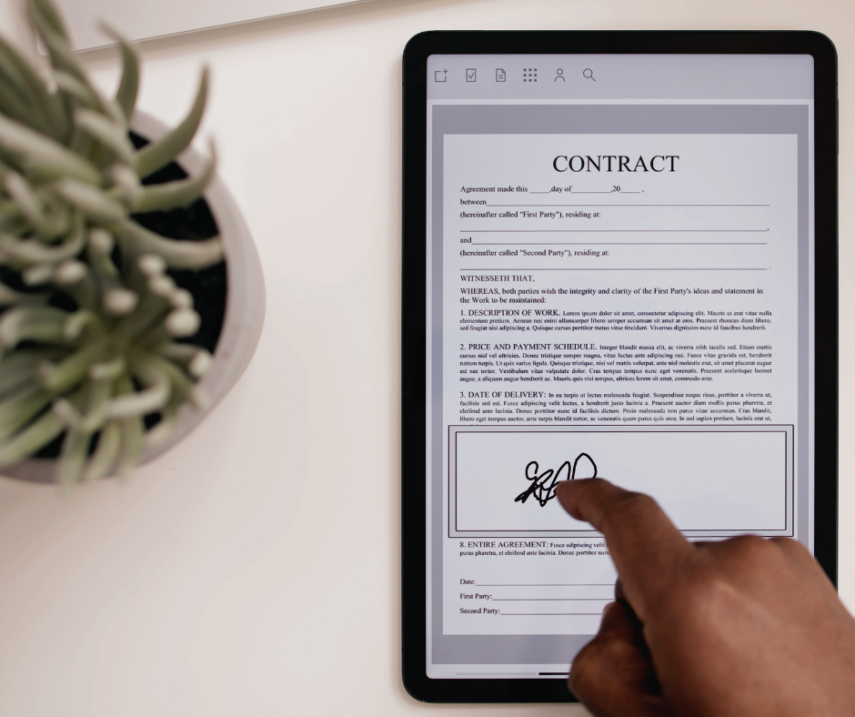 a woman's hand signs a contract on a tablet