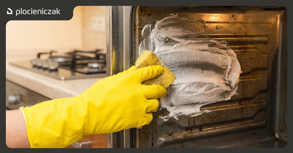 Nakładanie pasty z sody oczyszczonej na zabrudzone wnętrze piekarnika w gumowych rękawiczkach