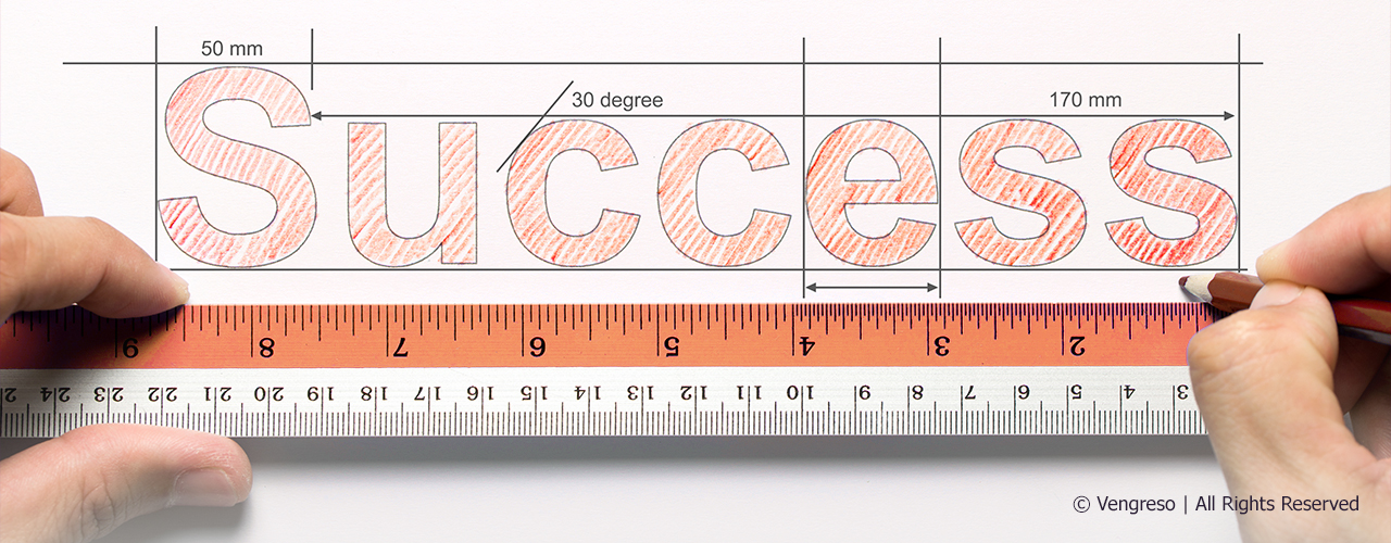 hands measuring with a ruler the word success 