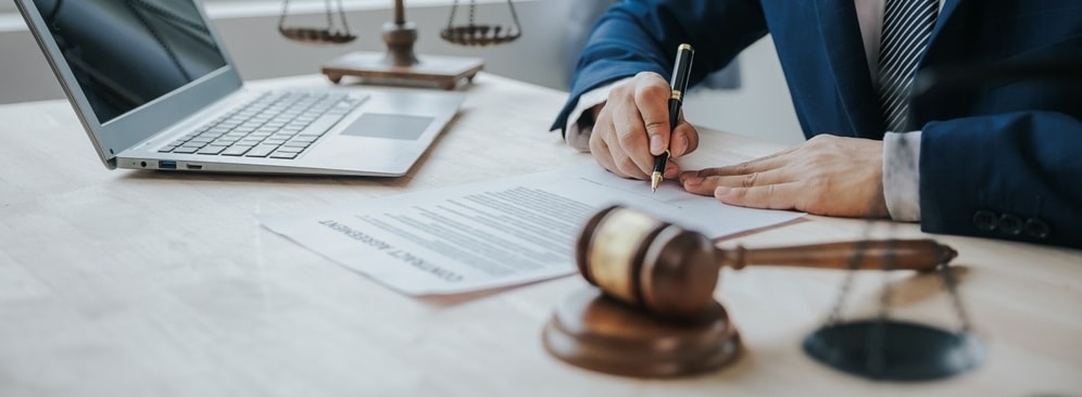 A gavel and legal documents on a desk, symbolizing justice and legal defense.