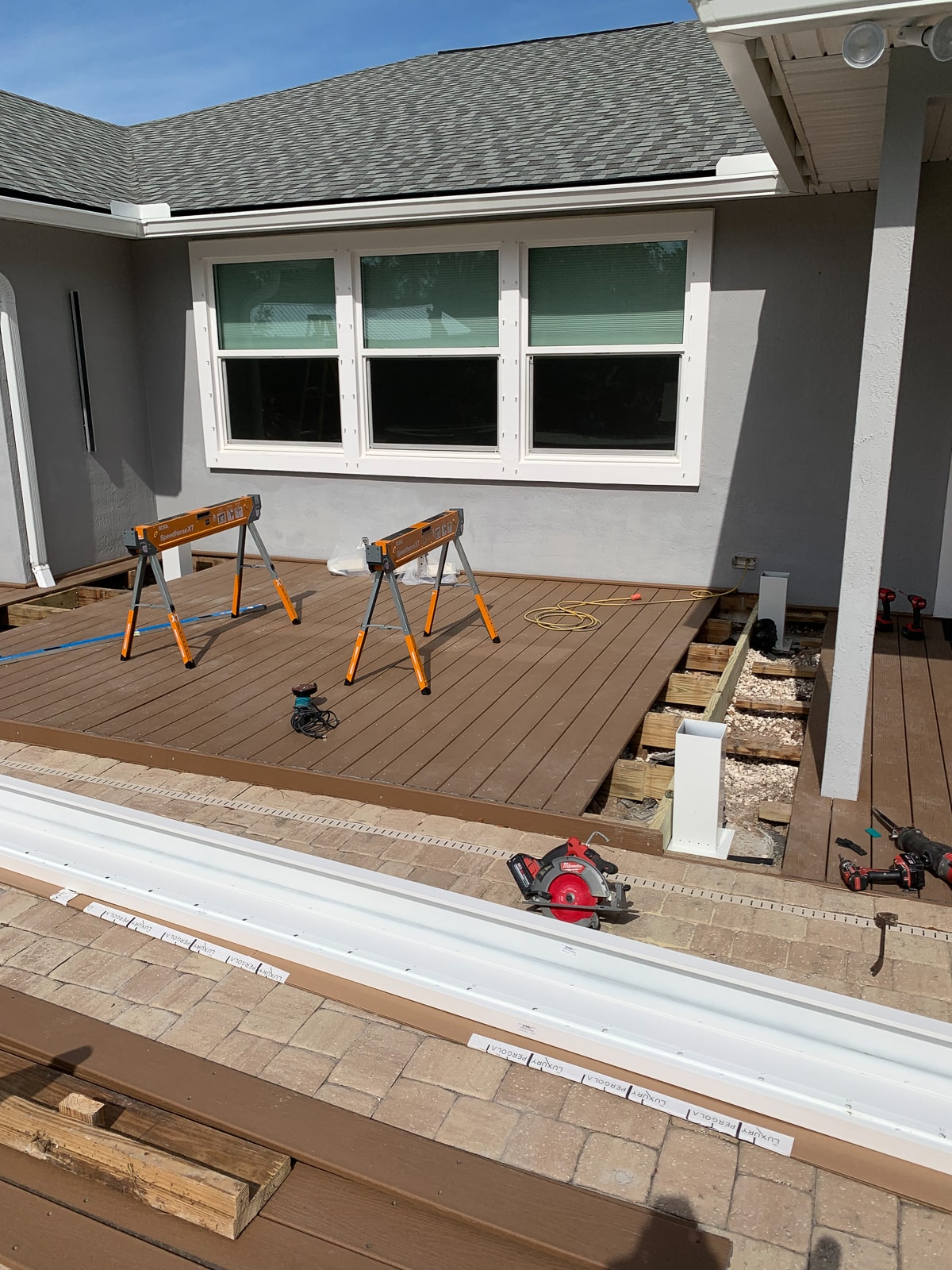 Outdoor living remodel underway with pergola installation.