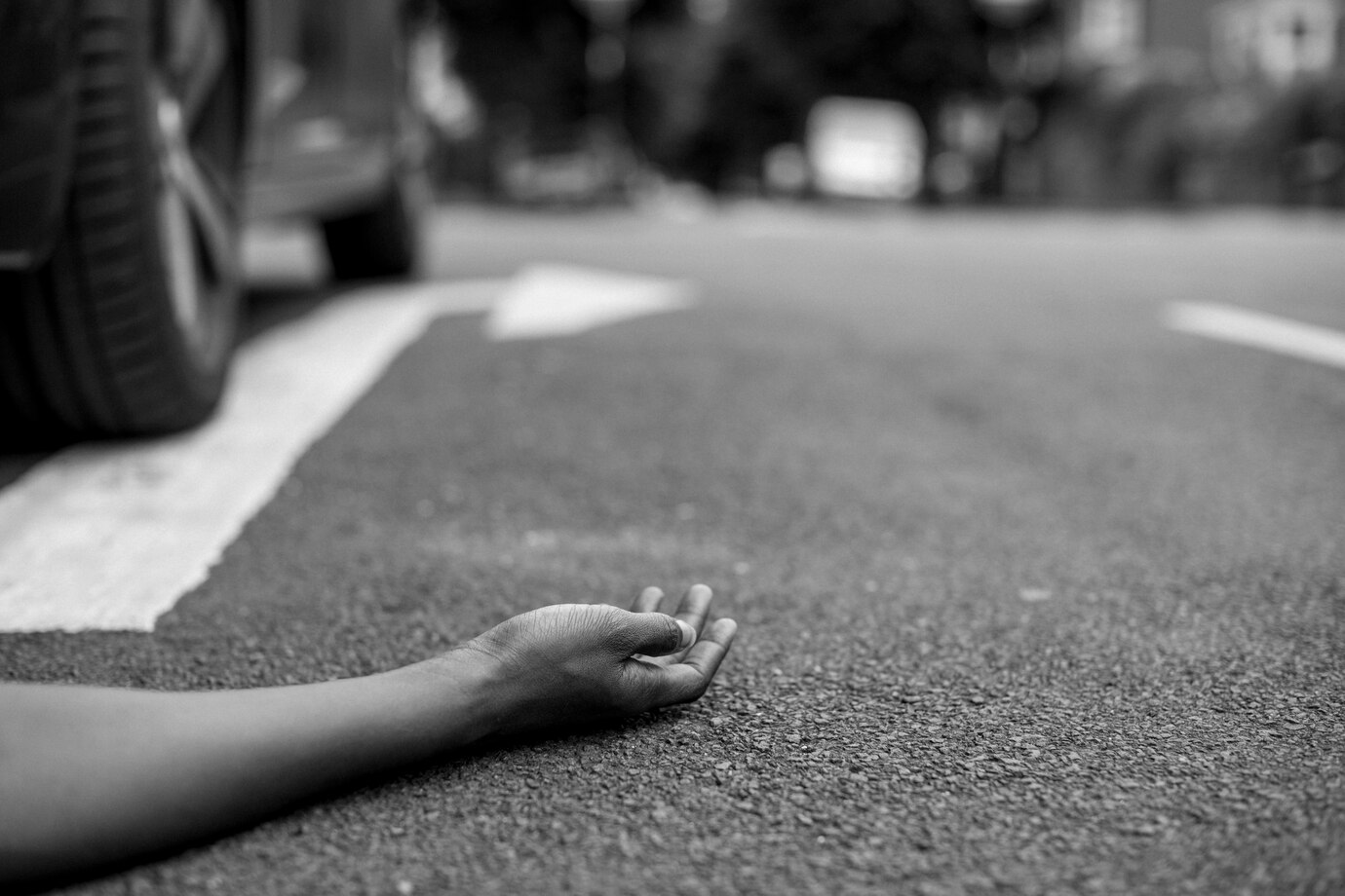 Hand on street in a traffic incident scene.