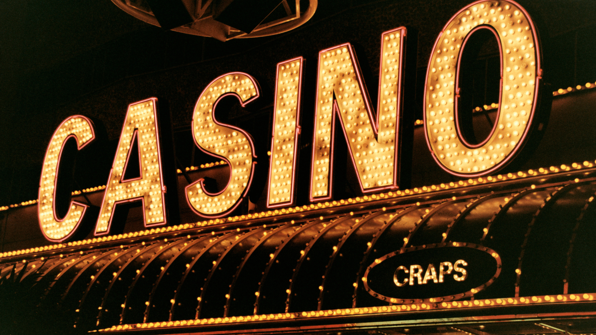 Fysiek casino met neonverlichting als vergelijking met legale online casino's in Nederland en legaal online gokken