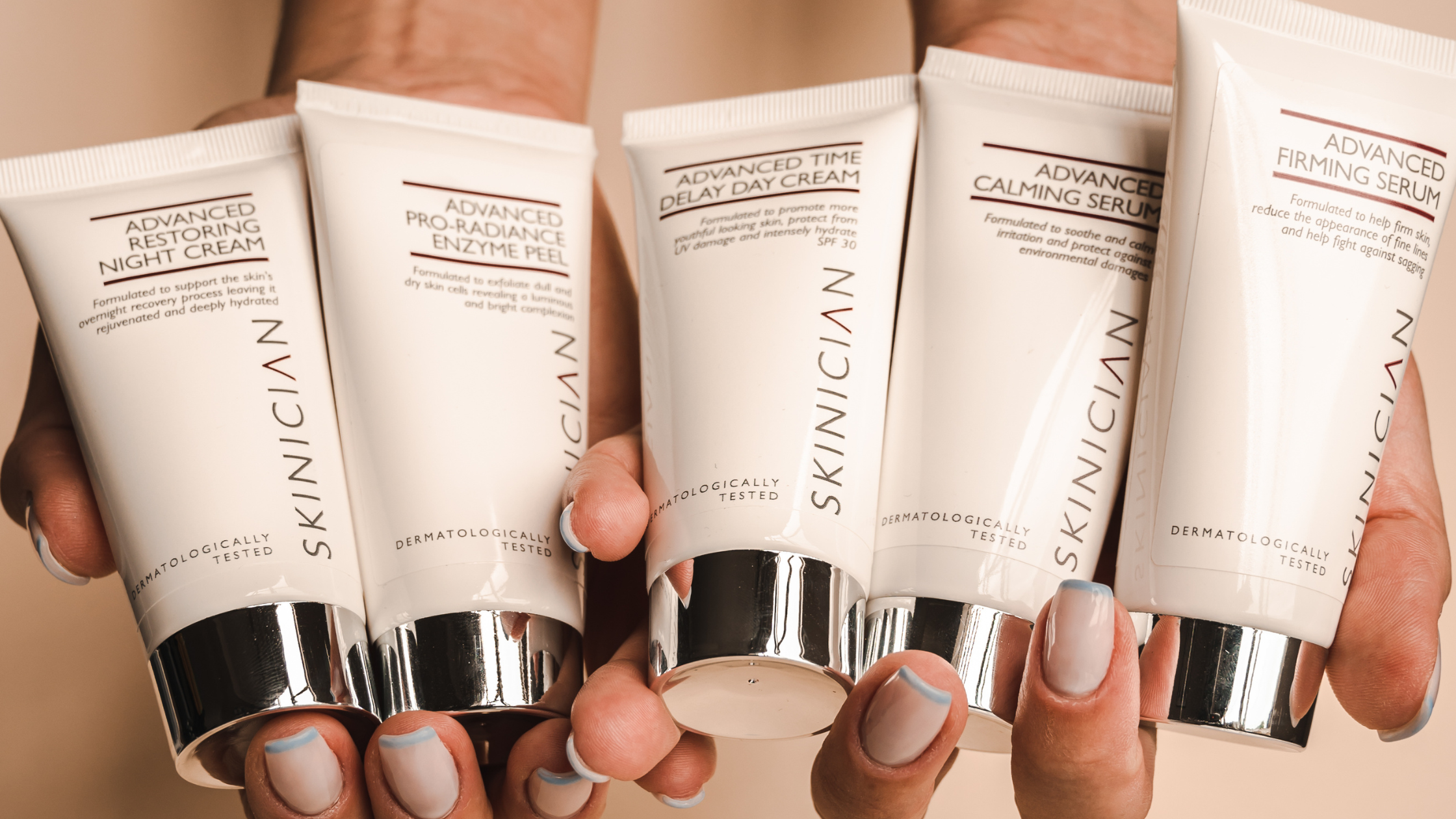 A tune of SKINICIAN's advanced skin care products held in hand.