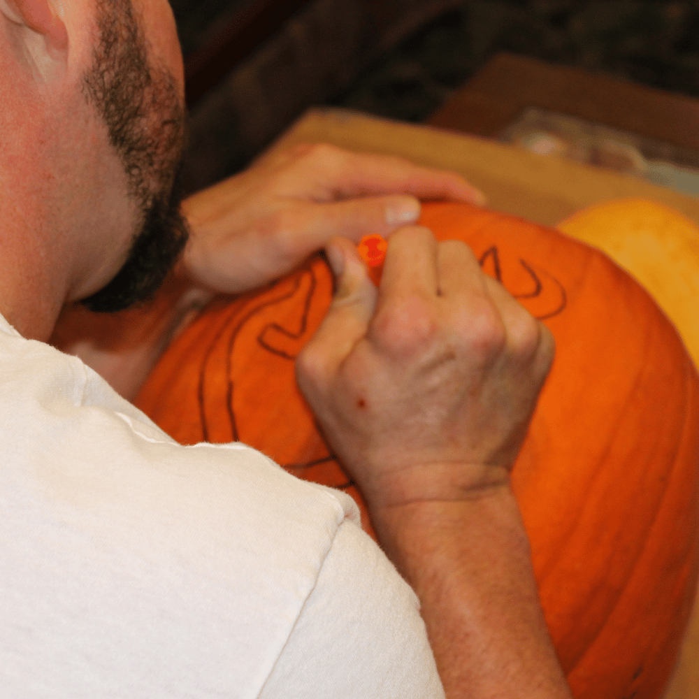A person holding a pumpkin carving kit