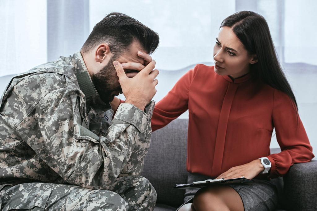 Soldier and psychiatrist sitting on couch during therapy session