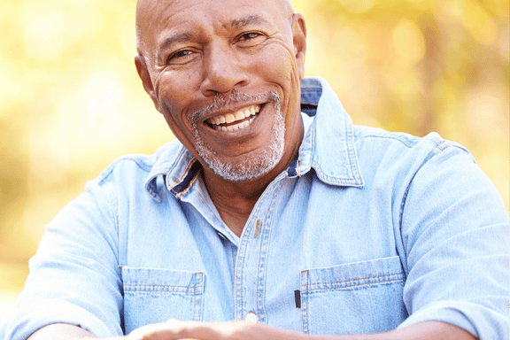 smiling senior male showing off his successful and natural looking dental implant crowns