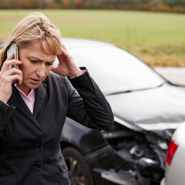 An image showing a person calling their insurance company to report an accident.