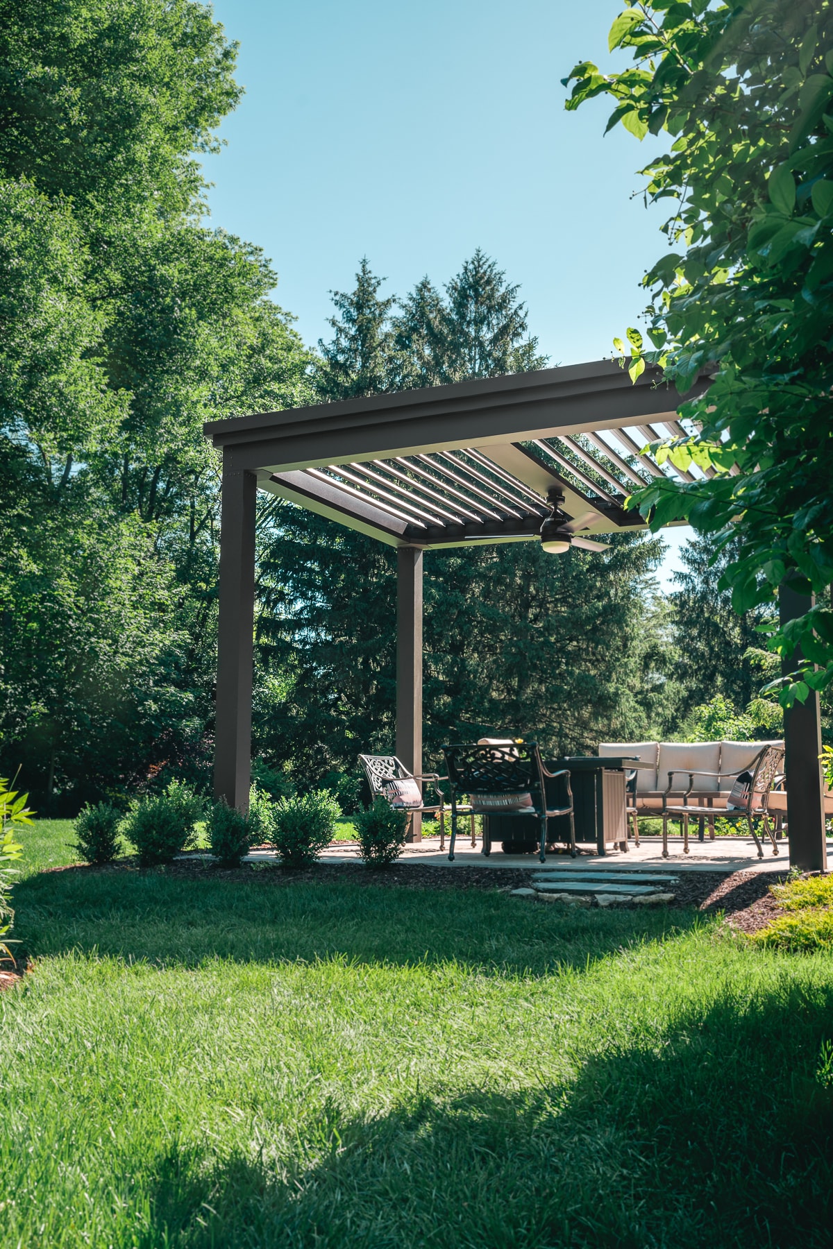 Freestanding DIY Pergola Kit installed over small patio with outdoor seating and heater.