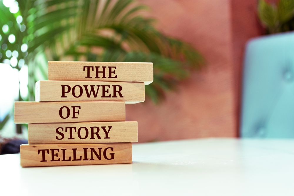 Tell  Your Story. "The Power Of Storytelling" spelled out on stacked wooden blocks. 