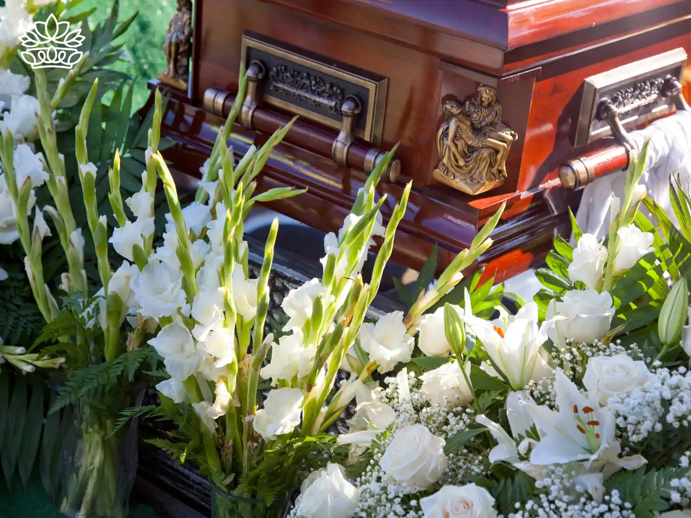 Beautiful floral tributes surrounding a polished wooden casket at a funeral. Fabulous Flowers and Gifts Funeral Collection.