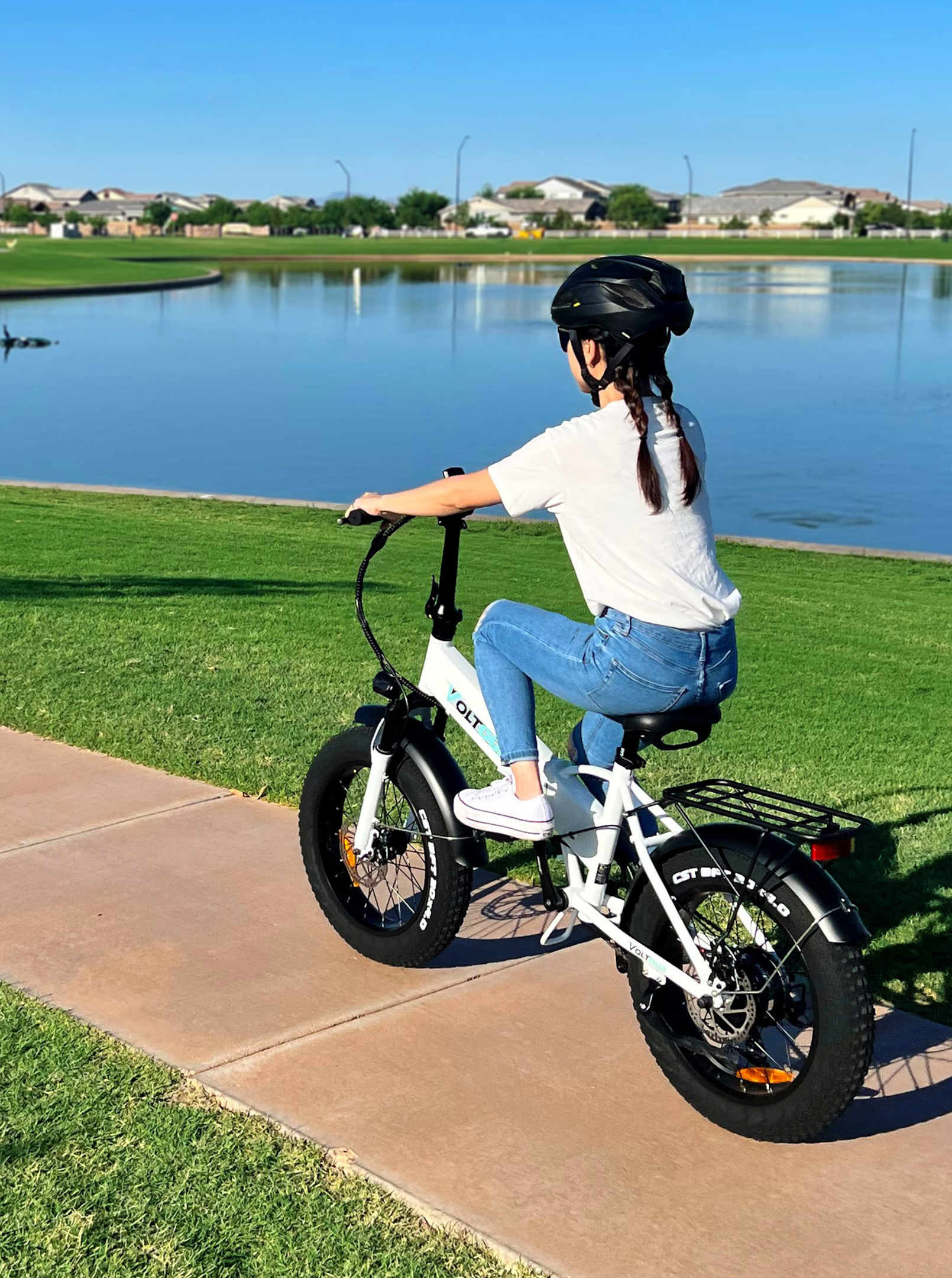 person on white foldable ebike riding by lake