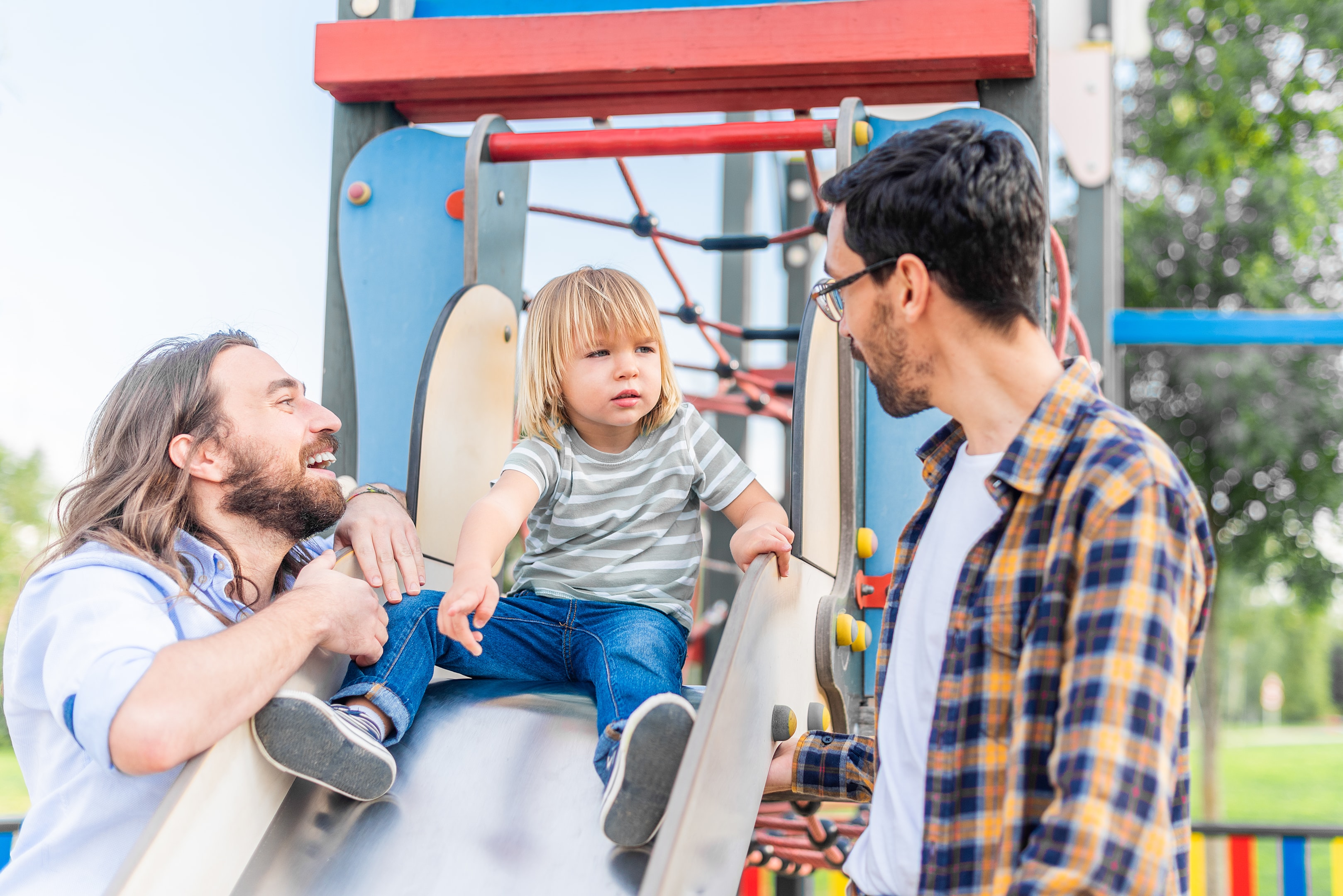Family experiencing parenting disagreement at Central Park playground in Manhattan.