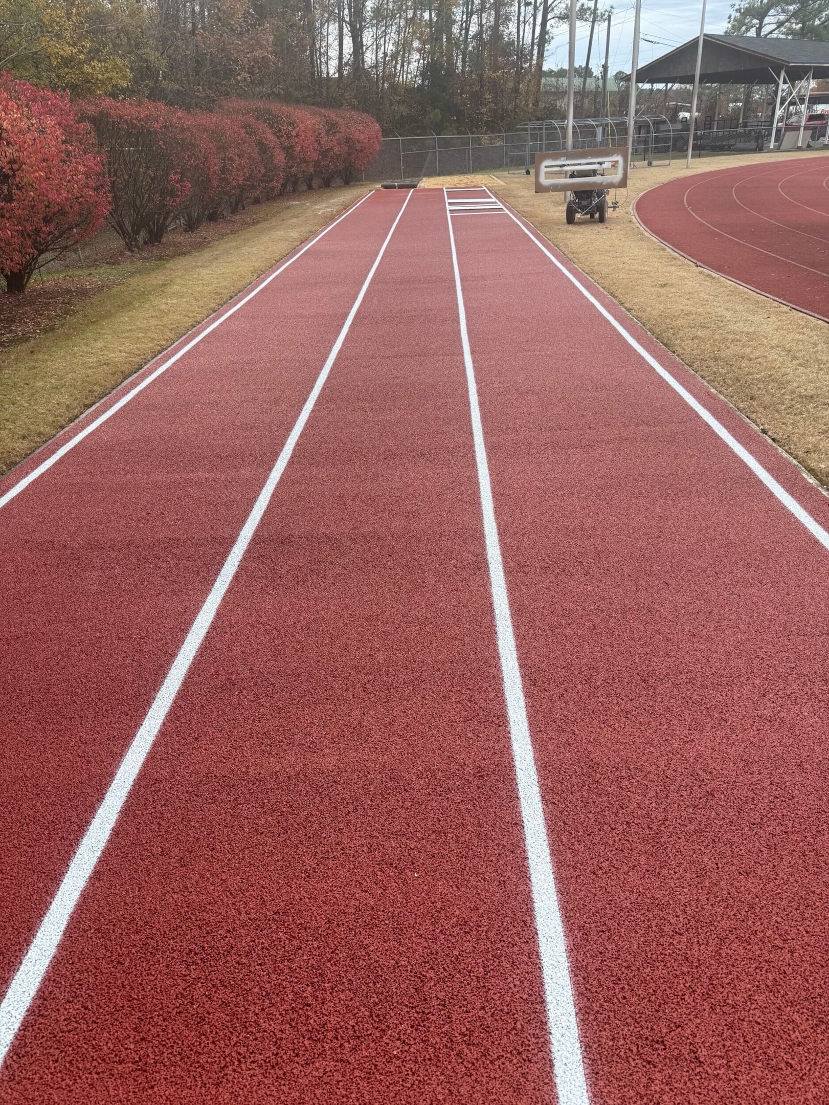 Newly installed synthetic running track surface during curing period before full use.
