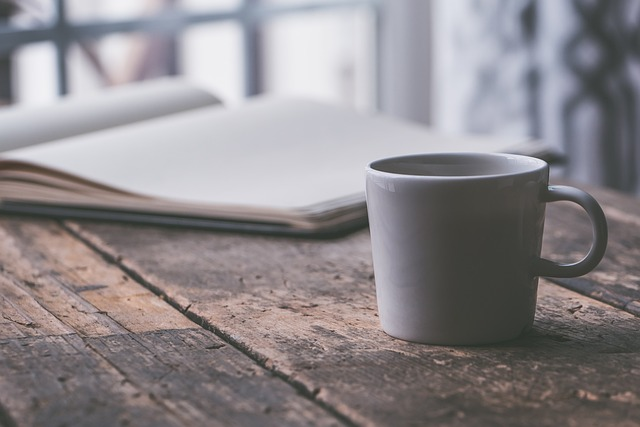 coffee, cup on a table an open book beside it