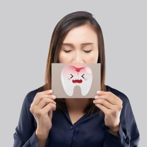 woman holding tooth with cavity from sugar