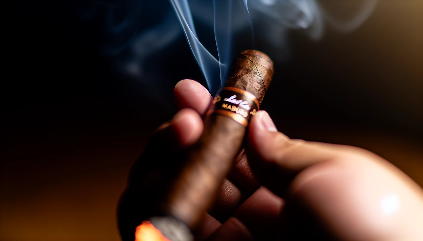 A close-up of a lit Last Call Maduro cigar with billowing smoke