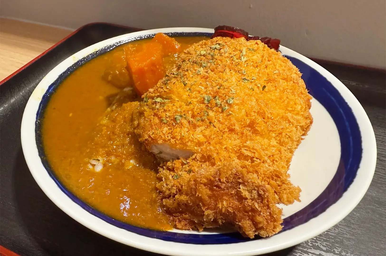 Crispy golden pork katsu served with rich Japanese curry sauce, carrots, and rice at Karekami in Singapore.