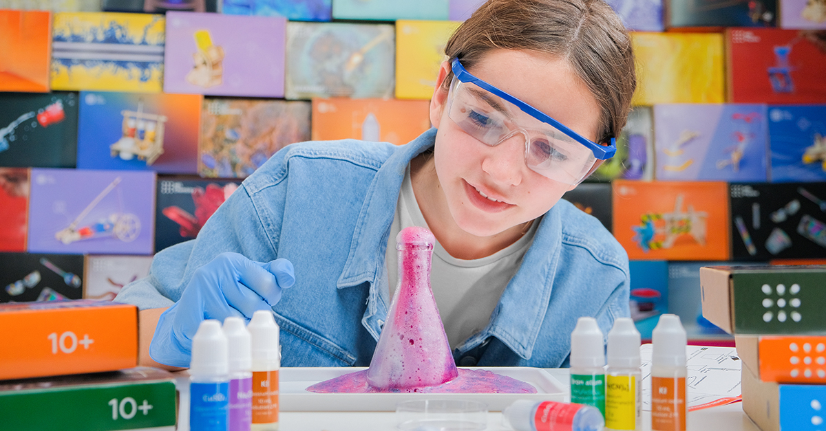 A picture of a child doing a chemistry experiment with a chemistry set and a lab notebook