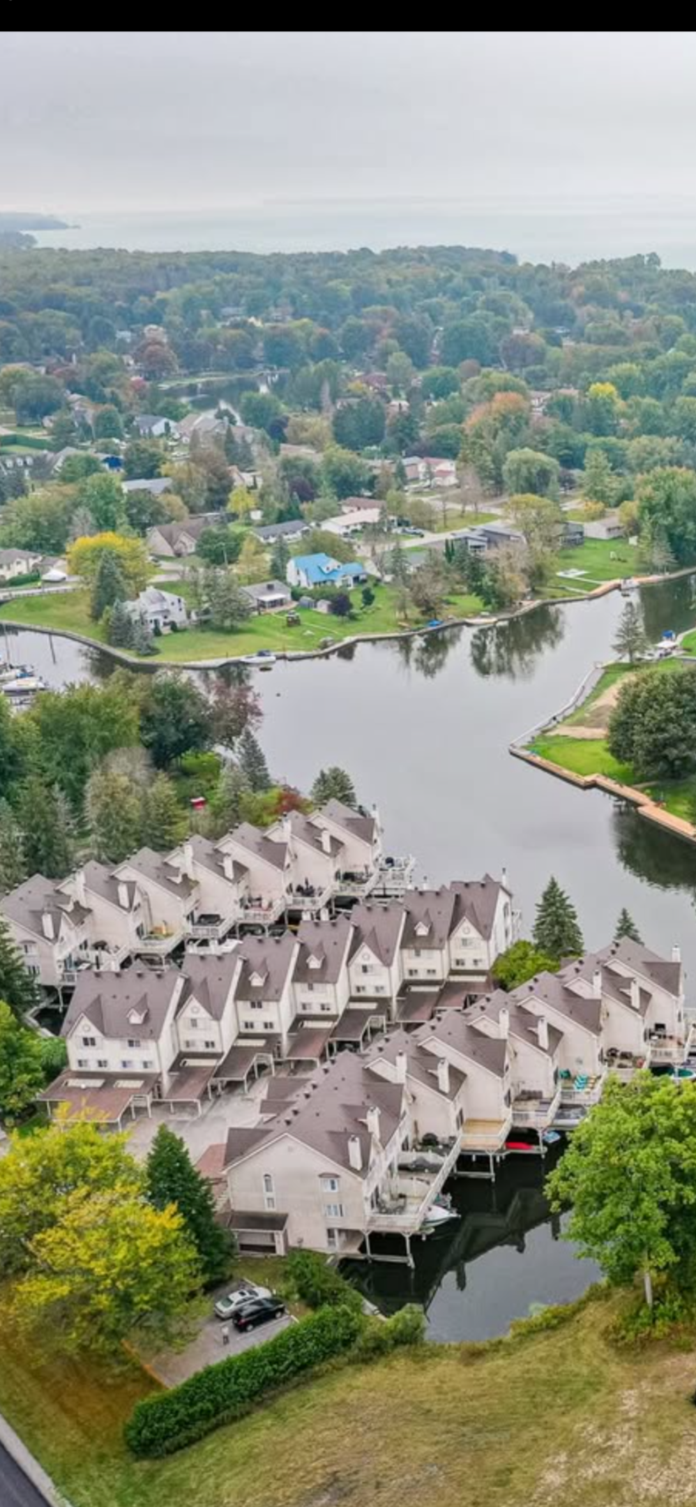 Aerial view of a serene lake surrounded by houses, showcasing the natural landscape and residential area.