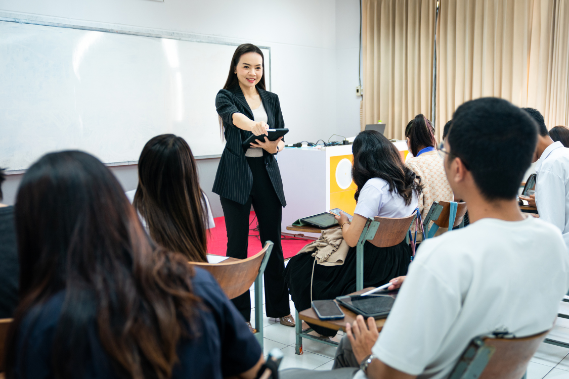 Filipino teacher engaging students during a college classroom lecture