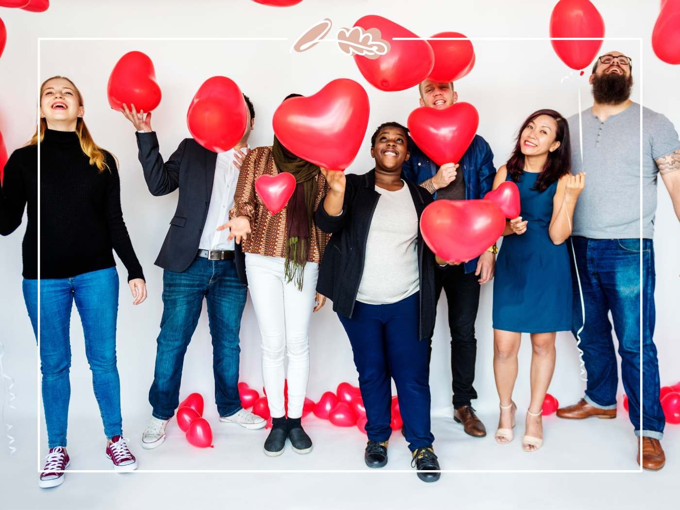 Diverse group of friends posing with red heart balloons, joyful Valentine’s celebration on a clean white backdrop.