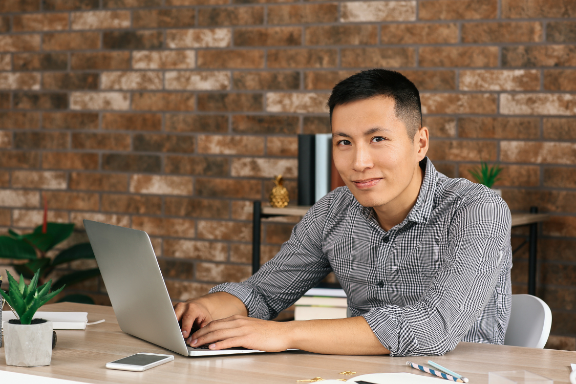 Confident Filipino candidate working on a laptop in a home office