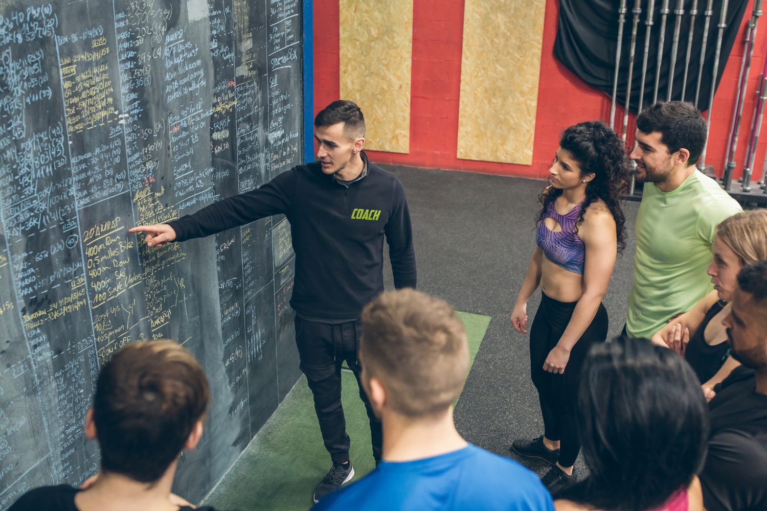 A fitness coach talking to a group of athletes.