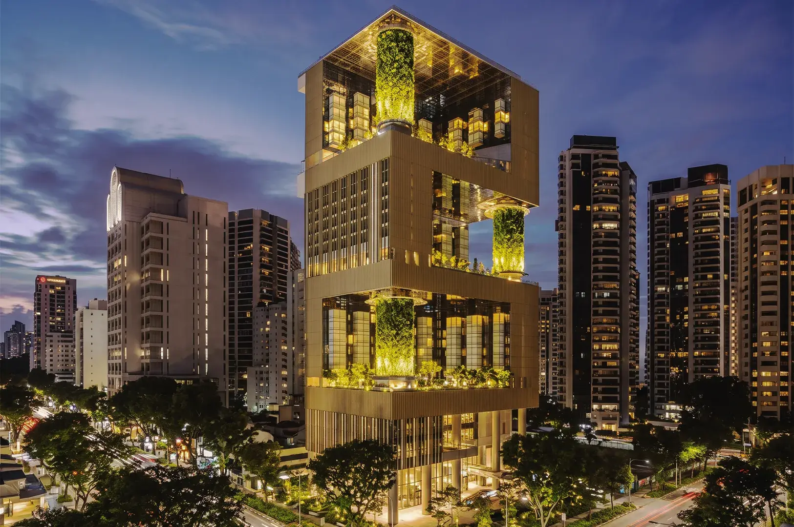 Luxury resort swimming pool surrounded by tropical palm trees, illuminated hotel balconies, and tranquil evening ambiance