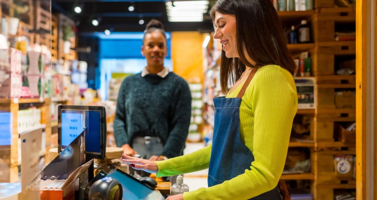 Business owner helping a client make a payment for CBD products in store.