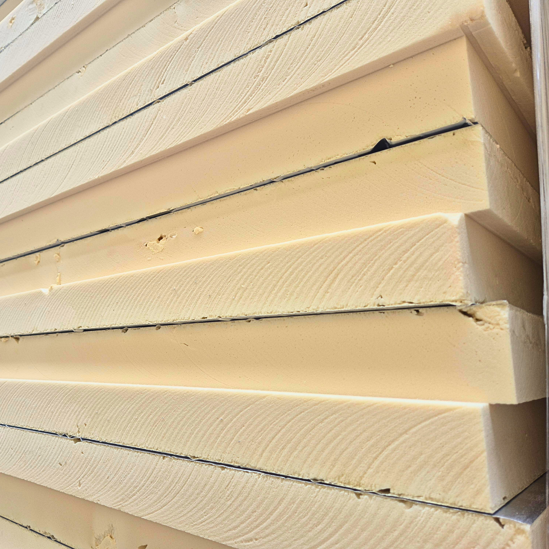 Na obrazie widoczny jest stos płyt izolacyjnych PIR, pokrytych srebrną folią aluminiową, ułożonych na palecie budowlanej. Płyty te charakteryzują się wysoką efektywnością energetyczną oraz właściwościami izolacyjnymi, co czyni je idealnym materiałem do ocieplania dachów, podłóg, fundamentów, elewacji i poddaszy budynków mieszkalnych