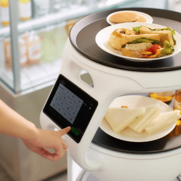 A restaurant worker using the Servi touch screen to handle orders.