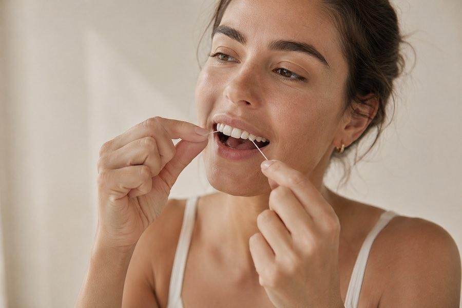 woman using dental floss