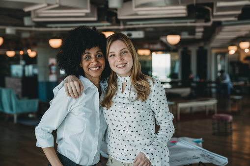 Two women supporting eachother at work. Support other women. Being just a good friend, honoring self esteem, and acknowledging another woman's success.