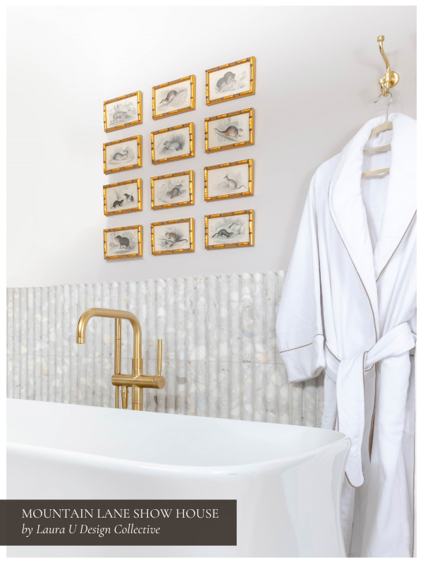 fluted tile (one of our favorite 2025 tile trends) surrounding a tub with framed drawings above and a bathrobe to the right