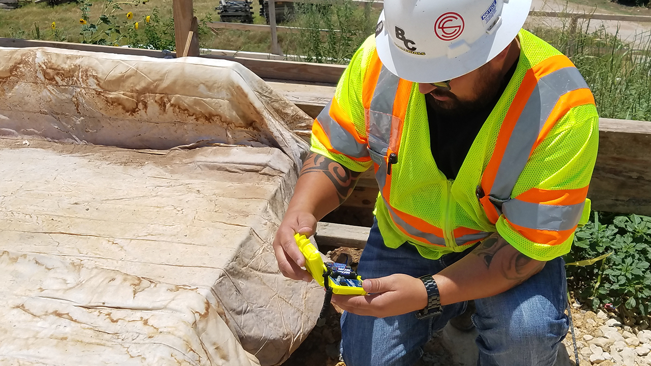 A technician using a maturity meter on a job site