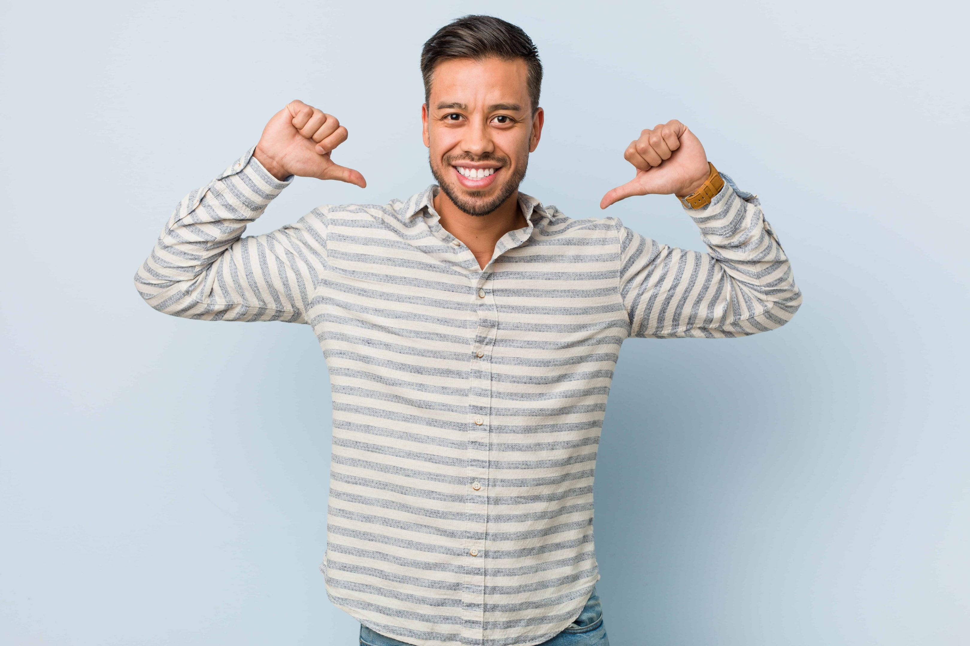 a guy with both hands pointing at himself in a stripe shirt.